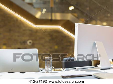 Laptop and computer on desk with water glass and paperwork View Large Photo Image Stock Image - Laptop and computer on desk with water glass and paperwork. Fotosearch
