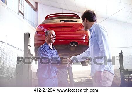 Mechanic and customer handshaking in auto repair shop View Large Photo Image Picture - Mechanic and customer handshaking in auto repair shop. Fotosearch