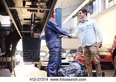 Picture - Mechanic and customer handshaking in auto repair shop. Fotosearch