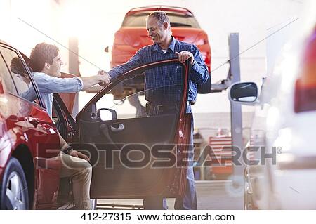 Mechanic and customer in car handshaking in auto repair shop View Large Photo Image Stock Photography - Mechanic and customer in car handshaking in auto repair shop. Fotosearch