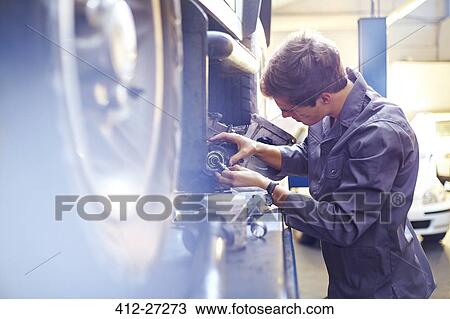 Mechanic examining part in auto repair shop View Large Photo Image Stock Image - Mechanic examining part in auto repair shop. Fotosearch