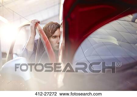 Mechanic looking inside car View Large Photo Image Stock Image - Mechanic looking inside car. Fotosearch