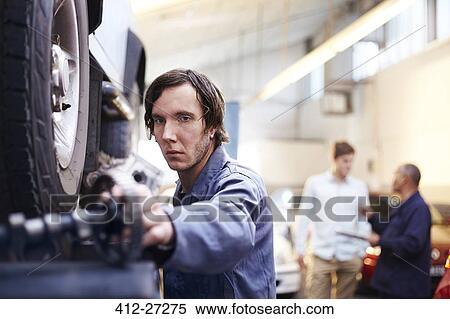 Mechanic reaching for part in auto repair shop View Large Photo Image Stock Photography - Mechanic reaching for part in auto repair shop. Fotosearch