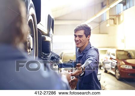 Mechanic reaching for tool in auto repair shop View Large Photo Image Stock Photograph - Mechanic reaching for tool in auto repair shop. Fotosearch