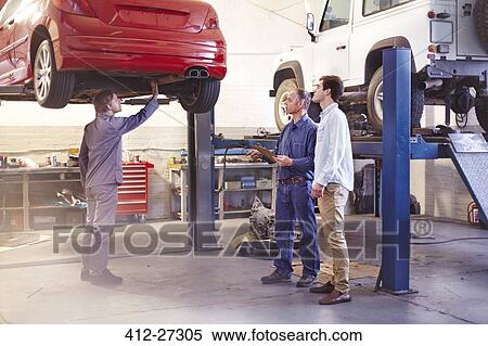 Mechanic talking to customer in auto repair shop View Large Photo Image Stock Photography - Mechanic talking to customer in auto repair shop. Fotosearch