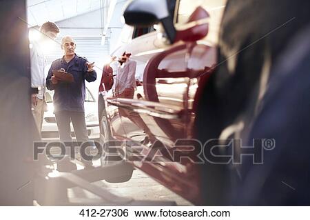 Mechanic with clipboard talking to customer in auto repair shop View Large Photo Image Stock Photograph - Mechanic with clipboard talking to customer in auto repair shop. Fotosearch