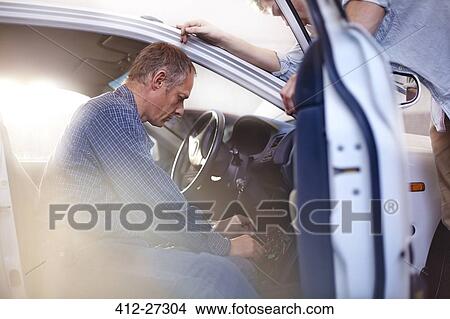 Mechanic working inside car in auto repair shop View Large Photo Image Picture - Mechanic working inside car in auto repair shop. Fotosearch