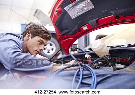 Mechanic working on car engine View Large Photo Image Picture - Mechanic working on car engine. Fotosearch