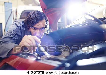 Mechanic working on engine in auto repair shop View Large Photo Image Stock Photo - Mechanic working on engine in auto repair shop. Fotosearch