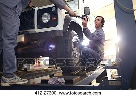 Stock Image - mechanics working in auto repair shop. Fotosearch