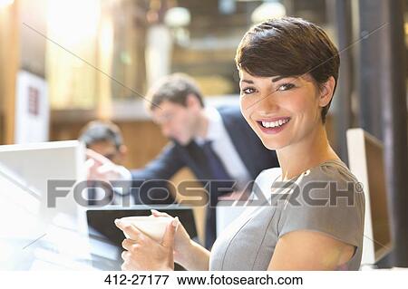 Portrait confident businesswoman drinking coffee in office View Large Photo Image Stock Photo - Portrait confident businesswoman drinking coffee in office. Fotosearch
