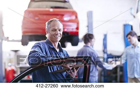 Stock Image - Portrait confident mechanic in auto repair shop. Fotosearch