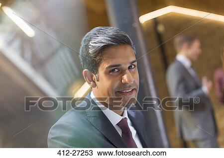 Stock Image - Portrait smiling businessman in office. Fotosearch