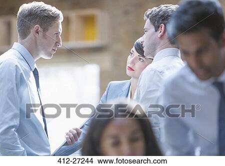 Picture - Serious business people talking in office. Fotosearch