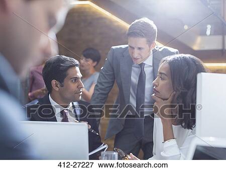 Serious business people talking in office View Large Photo Image Stock Photo - Serious business people talking in office. Fotosearch