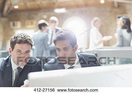 Stock Photograph - Serious businessmen using computer in office. Fotosearch