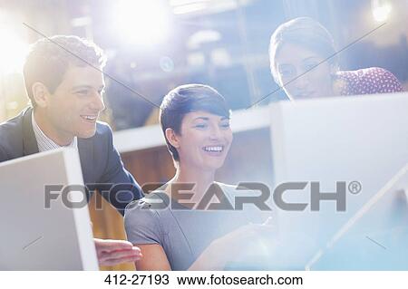 Smiling business people working at computer in office View Large Photo Image Stock Image - Smiling business people working at computer in office. Fotosearch