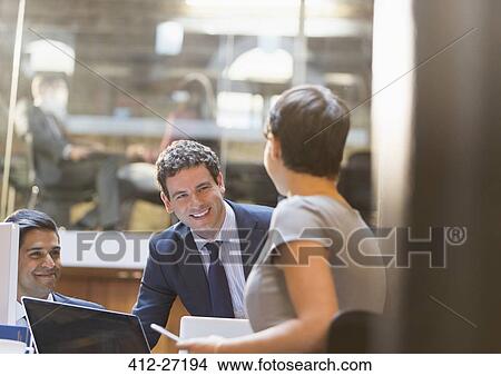 Smiling business people working in office View Large Photo Image Picture - Smiling business people working in office. Fotosearch