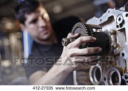 Stock Photography - Close up mechanic fixing part in auto repair shop. Fotosearch