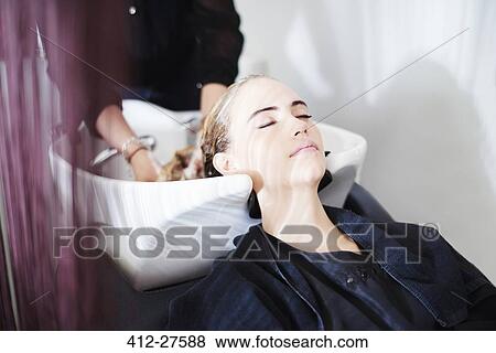 Customer with eyes closed getting hair washed in salon View Large Photo Image Stock Photo - Customer with eyes closed getting hair washed in salon. Fotosearch