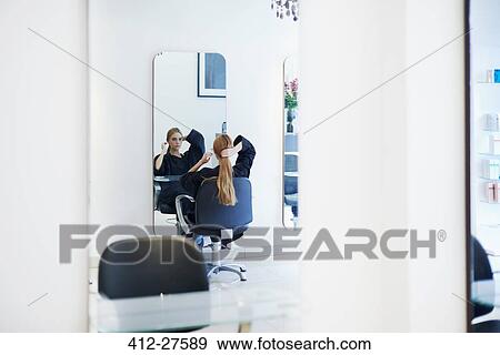 Customer with long hair looking into mirror in hair salon View Large Photo Image Stock Photo - Customer with long hair looking into mirror in hair salon. Fotosearch
