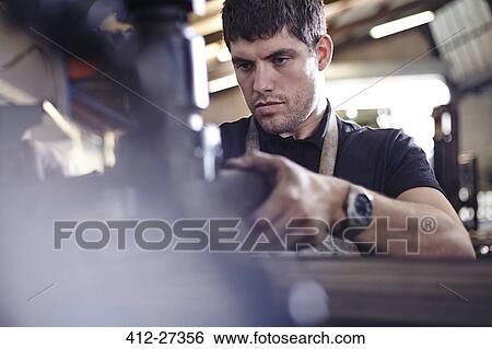Stock Photograph - Focused mechanic working in auto repair shop. Fotosearch