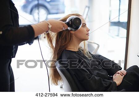 Hairdresser drying customer’s long hair in salon View Large Photo Image Picture - Hairdresser drying customer’s long hair in salon. Fotosearch
