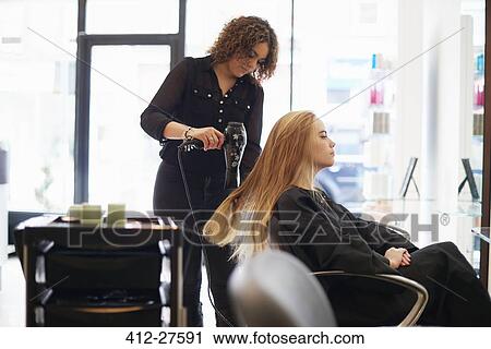 Hairdresser drying customer’s long hair in salon View Large Photo Image Stock Image - Hairdresser drying customer’s long hair in salon. Fotosearch