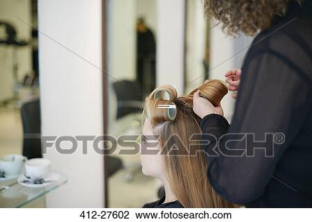 Hairdresser rolling customer’s hair in curlers in salon View Large Photo Image Stock Image - Hairdresser rolling customer’s hair in curlers in salon. Fotosearch