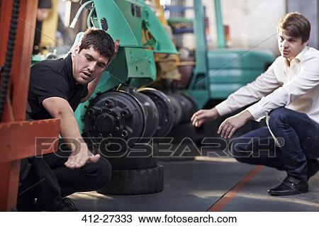 Mechanic and customer talking in auto repair shop View Large Photo Image Stock Image - Mechanic and customer talking in auto repair shop. Fotosearch