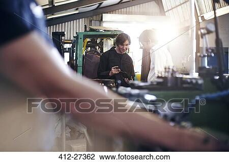 Mechanic and customer talking in auto repair shop View Large Photo Image Stock Image - Mechanic and customer talking in auto repair shop. Fotosearch