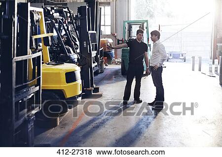 Stock Photo - Mechanic and customer talking in auto repair shop. Fotosearch