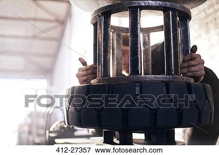 Mechanic using tire machine in auto repair shop View Large Photo Image Stock Photo - Mechanic using tire machine in auto repair shop. Fotosearch