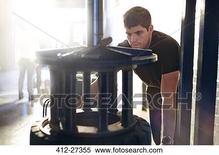 Stock Photography - Mechanic using tire machinery in auto repair shop. Fotosearch