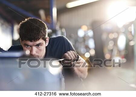 Stock Photograph - Mechanic working in auto repair shop. Fotosearch