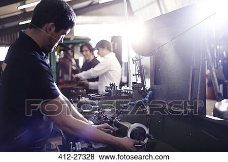 Mechanic working on machinery part in auto repair shop View Large Photo Image Stock Photo - Mechanic working on machinery part in auto repair shop. Fotosearch