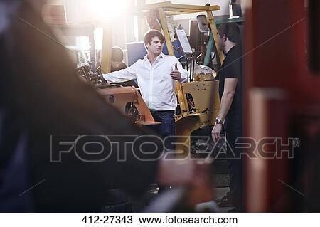 Mechanics talking in auto repair shop View Large Photo Image Stock Image - Mechanics talking in auto repair shop. Fotosearch