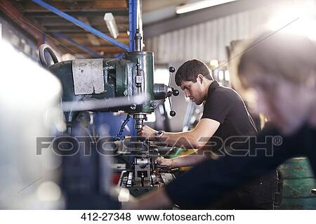 Mechanics using machinery in auto repair shop View Large Photo Image Stock Photo - Mechanics using machinery in auto repair shop. Fotosearch