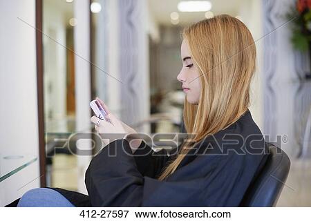 Woman texting with cell phone in hair salon View Large Photo Image Stock Photo - Woman texting with cell phone in hair salon. Fotosearch