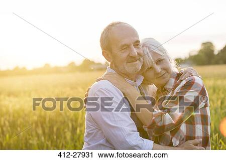 Affectionate serene senior couple hugging in sunny rural wheat field View Large Photo Image Stock Image - Affectionate serene senior couple hugging in sunny rural wheat field. Fotosearch