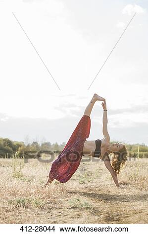 Boho woman in extended side plank yoga pose in sunny rural field View Large Photo Image Picture - Boho woman in extended side plank yoga pose in sunny rural field. Fotosearch