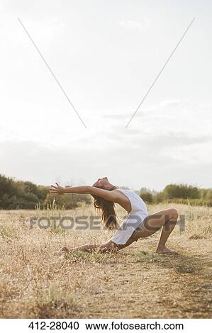 Boho woman in high crescent lunge yoga pose in sunny rural field View Large Photo Image Stock Image - Boho woman in high crescent lunge yoga pose in sunny rural field. Fotosearch