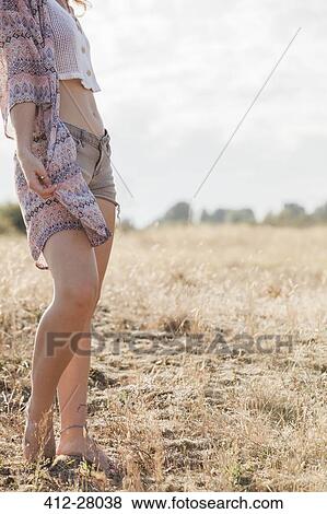 Boho woman standing in sunny rural field View Large Photo Image Stock Photo - Boho woman standing in sunny rural field. Fotosearch
