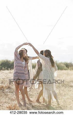 Boho women dancing in circle in sunny rural field View Large Photo Image Stock Photography - Boho women dancing in circle in sunny rural field. Fotosearch