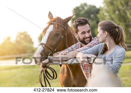 Couple with horse talking at rural pasture fence View Large Photo Image Picture - Couple with horse talking at rural pasture fence. Fotosearch