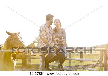 Couple with horse talking on sunny rural pasture fence View Large Photo Image Stock Image - Couple with horse talking on sunny rural pasture fence. Fotosearch