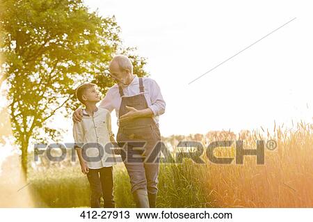 Grandfather farmer talking to grandson in sunny rural wheat field View Large Photo Image Stock Image - Grandfather farmer talking to grandson in sunny rural wheat field. Fotosearch