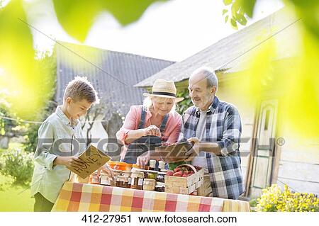 Grandparents and grandson selling honey at farmer’s market stall View Large Photo Image Stock Image - Grandparents and grandson selling honey at farmer’s market stall. Fotosearch