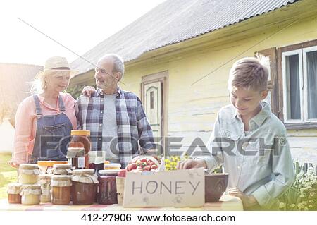 Stock Photograph - Grandparents and grandson selling honey. Fotosearch
