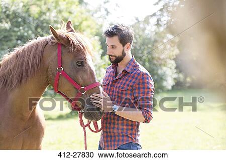 Man petting horse muzzle View Large Photo Image Stock Image - Man petting horse muzzle. Fotosearch